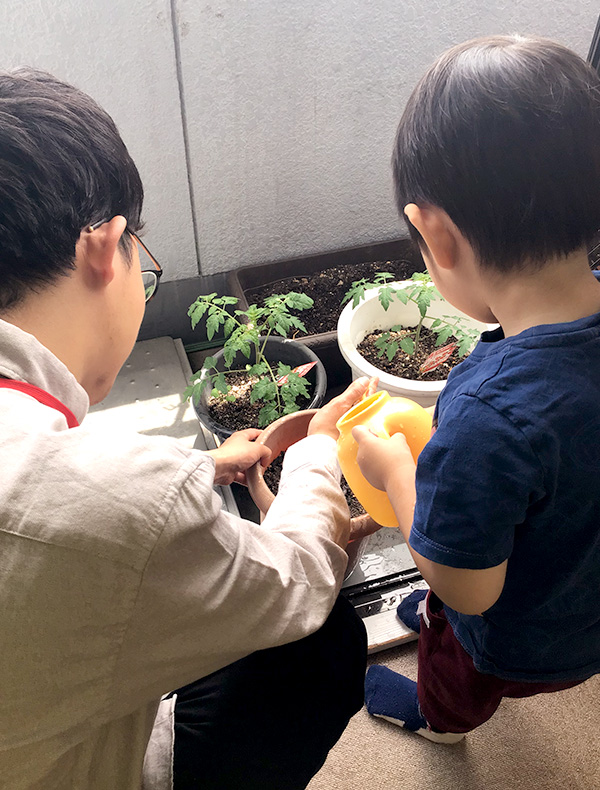 子供が植木に水をあげている様子