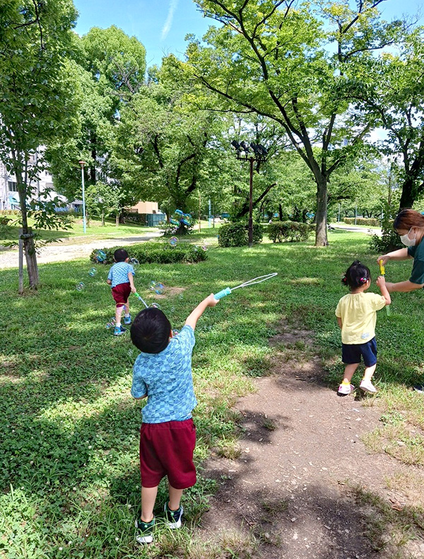 子供が植木の土をスコップで混ぜている様子